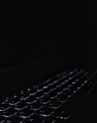 close-up-illuminated-computer-keyboard-against-black-background